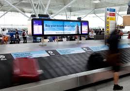 baggage pod at eye showing large screens in baggage hall of airport