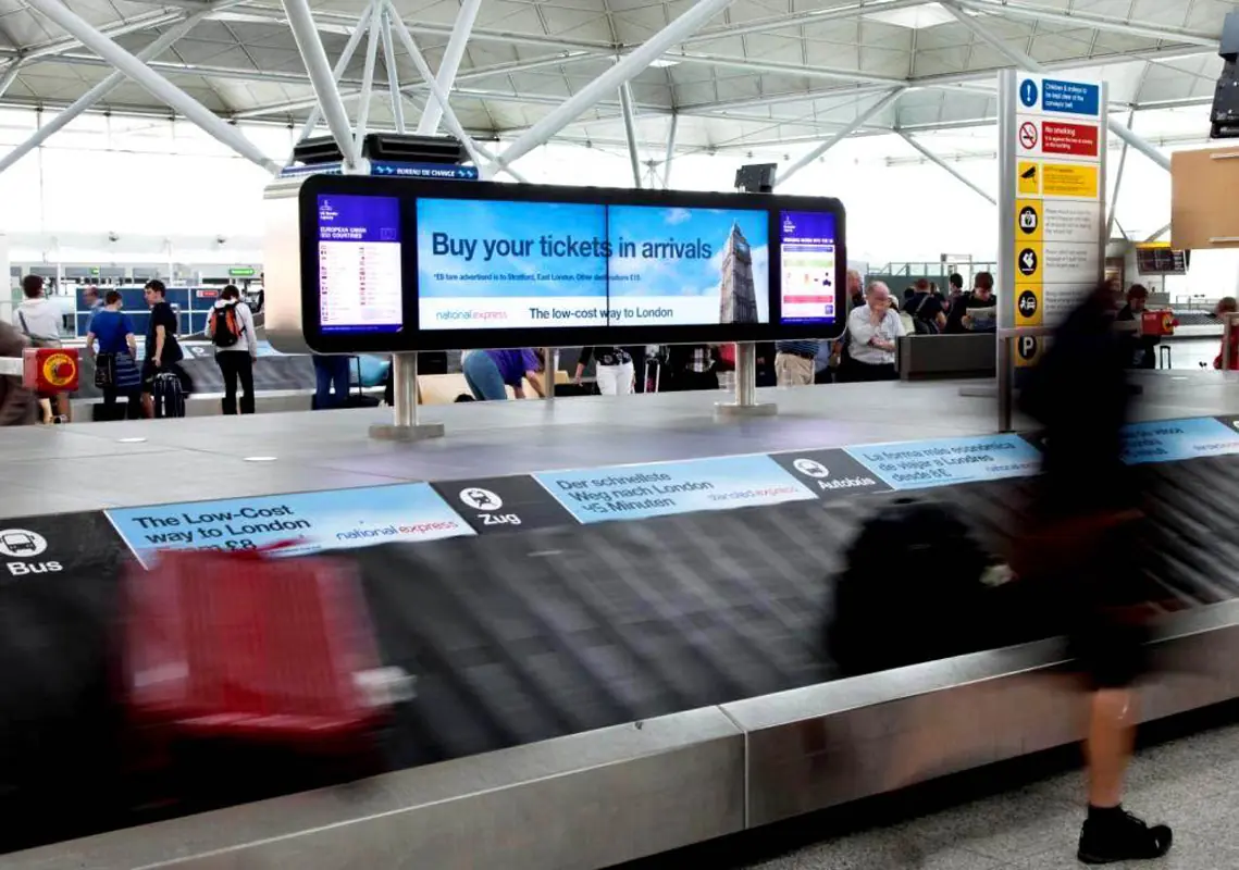 baggage carousel at airport showing digital displays