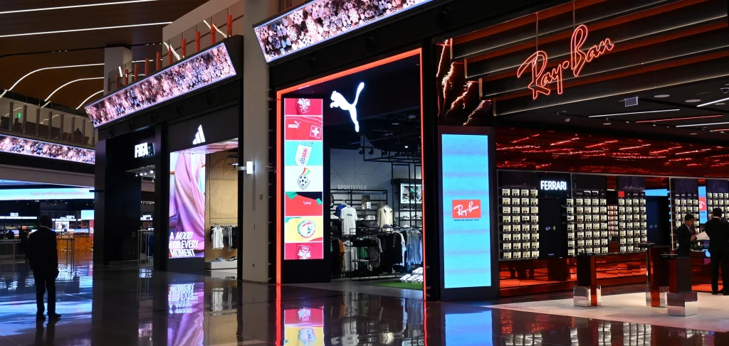 Retail digital signage examples in FIFA, Adidas, Puma and Ray Ban stores, showing vertical digital retail screens, people in stores and store fronts