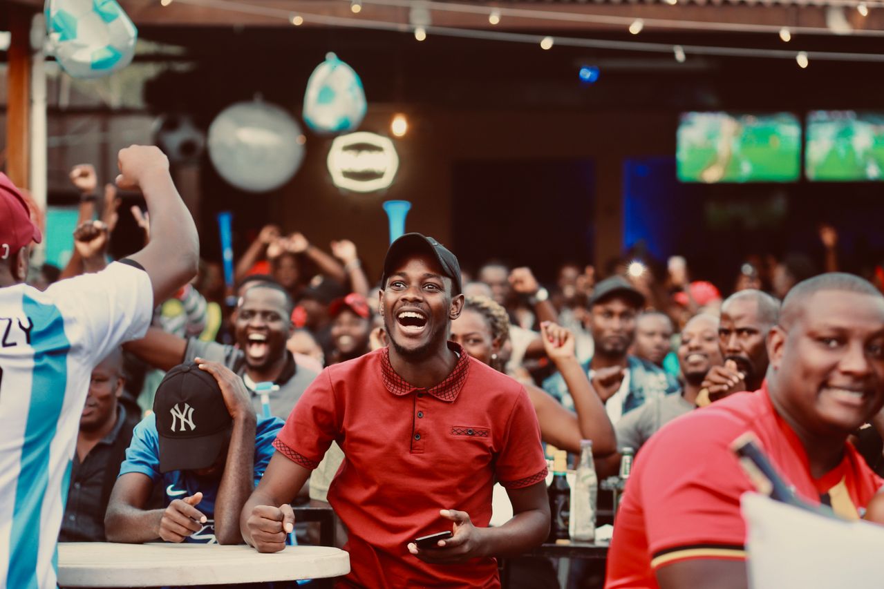 Discover how digital signage and LED displays help hospitality venues boost revenue, engage customers and enhance major sporting events. - image showing a crowded bar with sports fans enjoying themselves watching a match on a display